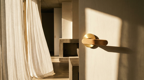 The Da Vinci Ratio - Gold installed on a wooden door in a warm minimalist interior with natural light and linen curtain