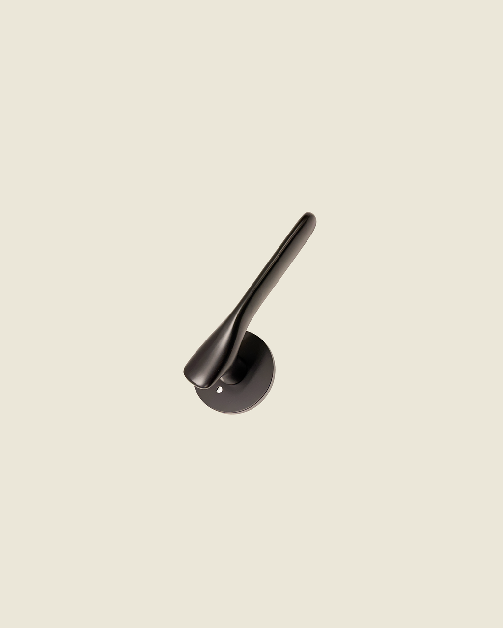 The Gaudi Curve - matte black brass door lever with fluid curved form and circular rose on neutral background