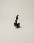 The Bauhaus Pull - matte black solid brass door lever with knurled grip on neutral background
