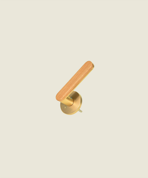 The Da Vinci Ratio in polished gold and wood combo. Door lever with light wood grip on polished circular rose, neutral background